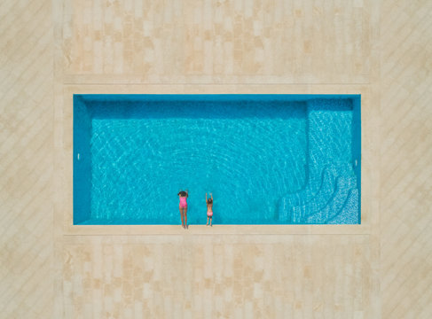 Aerial view of two girls diving into swimming pool, Sumartin, Croatia.