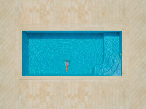Aerial view of girl diving into swimming pool, Sumartin, Croatia.