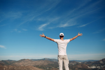 Young male rock climber on a cliff top