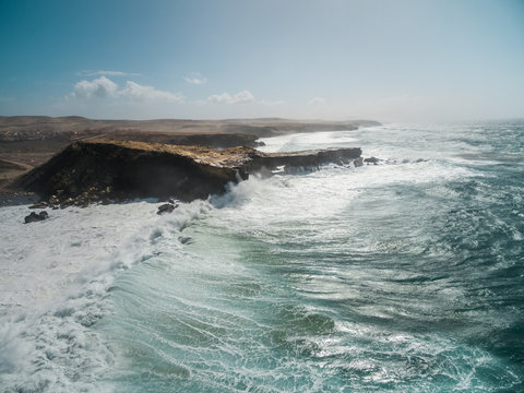 Aerial view of waves crashing of the rocks of punta Guadalupe in Fuerteventura, Canary Island.