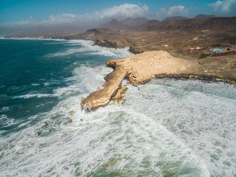 Aerial view of waves crashing of the rocks of punta Guadalupe in Fuerteventura, Canary Island.