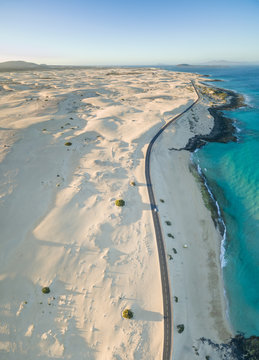 Aerial panoramic view of a car driving on the road in Corralejo Dunes Natural Park in Fuerteventura, Canary Islands.