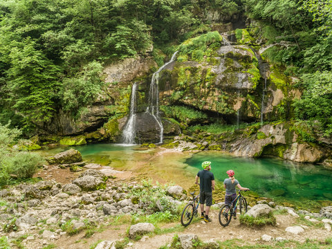 Aerial view of cyclists at Virje waterfall in Soca valley, Slovenia.
