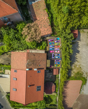 Aerial view of a group of people doing yoga on a terrace surrounded by trees in town
