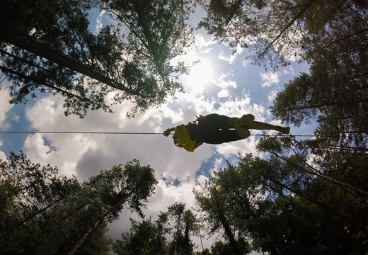 Aerial view of a person crossing the forest through a large zip line cable in Slovenia.