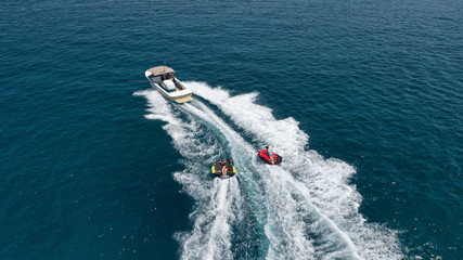 Aerial photo of extreme powerboat donut watersports crusing in high speed in tropical turquoise bay - obrazy, fototapety, plakaty