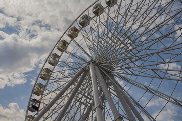 Ferris wheel on a background of blue sky and clouds