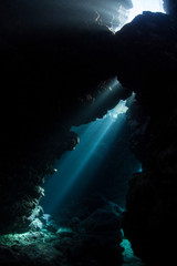 Light descends into the darkness of a submerged cavern in the Solomon Islands. Caves and caverns riddle coral reefs since limestone can be easily eroded.