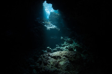 Light descends into the darkness of a submerged cavern in the Solomon Islands. Caves and caverns riddle coral reefs since limestone can be easily eroded.