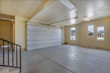 Empty garage with white doors as well as arched and rectangular windows