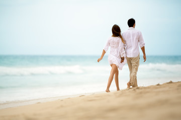 romantic couple walking on tropical beach
