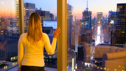 CLOSE UP: Woman views the breathtaking evening landscape of New York City.