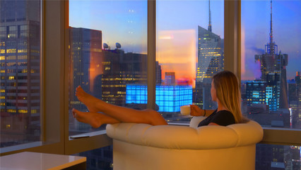 CLOSE UP: Female tourist drinking her morning coffee and observing the city.