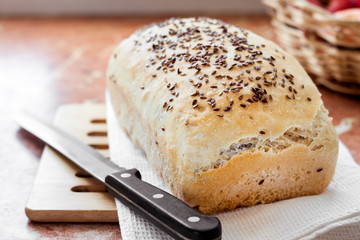 Homemade wheat bread with flax seeds on a kitchen table