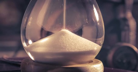 Pouring sand in an hourglass on an old diary - Powered by Adobe
