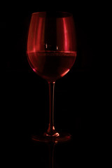 glass of red wine on black background