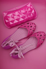 sandals and clutch on pink background, flat lay.