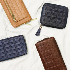 blue, beige and brown leather wallets on white background