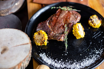 Grilled steak with corn and rosemary. Restaurant serving