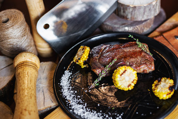 Grilled steak with corn and rosemary. Restaurant serving
