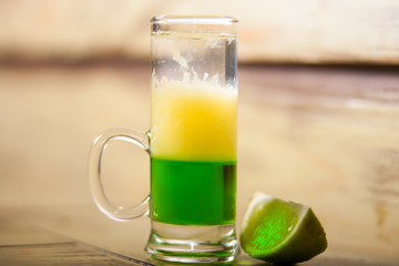 green mexican layered cocktail with lime slice
