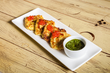 plate with potato pancakes, red caviar and pesto on wooden table