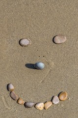 Fototapeta na wymiar Stones forming a smiling face on the sand