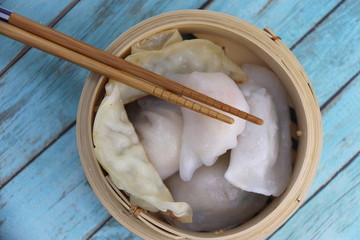 Gyozas dans un panier en bambou et une paire de baguettes