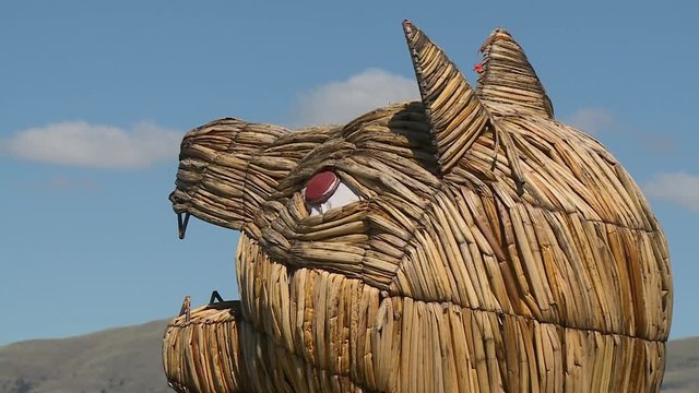 Extreme close-up low-angle still shot of a woven cat head on  a floating Uros reed boat, Uros Village, Lake Titicaca, Peru