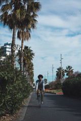 Man with afro hair jumping through the streets of a city