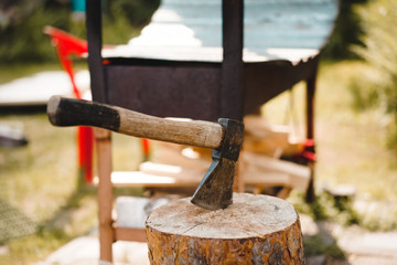 Wood work at country house. Hatchet with black hand. Camping 