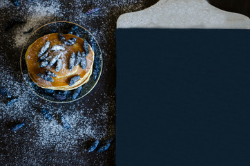 flat flay pancakes with honeysuckle and honey on a dark background. pancake week. Shrovetide week....
