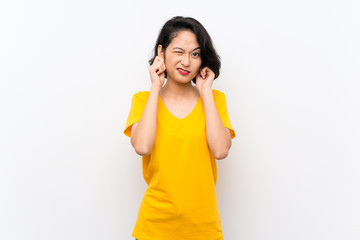 Asian young woman over isolated white background frustrated and covering ears