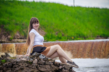 The girl at the waterfall. Young beautiful girl on a little waterfall. Little waterfall.