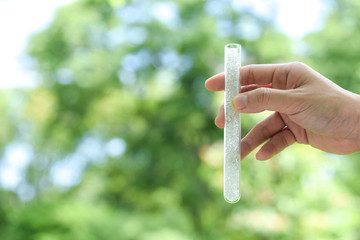 Hand holding Pet polyester chips,Plastic pet polyester chips,Chips bright in test tube with green...
