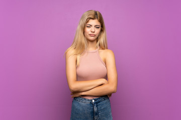 Teenager girl over isolated purple background feeling upset