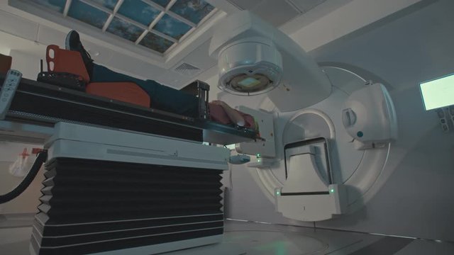 Patient Getting Radiation Therapy Treatment Inside A Modern Radiotherapy Room