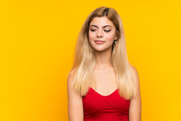 Teenager girl over isolated yellow background standing and looking to the side