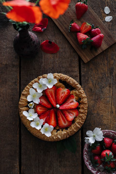 Strawberry tart with poppy flowers on a wooden table