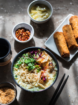 Japanese ramen with noodles and pork dumplings topped with mocrogreens.