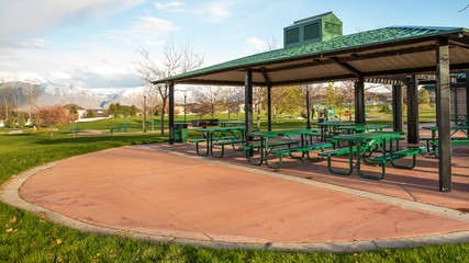 Panorama frame Covered picnic area on a scenic park under cloudy blue sky