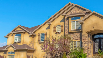 Panorama frame House with stairs on the landscaped yard leading to the wrought iron front door