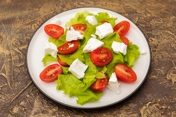 salad with cherry tomatoes, soft brynza cheese and lettuce leaves. Dietary meal