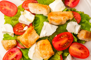 Dietary dish. salad with chicken, cherry tomatoes and soft cheese cheese. dressing with olive oil. Close up