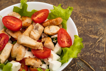 Salad with chicken, cherry tomatoes and soft cheese cheese. dressing with olive oil. Copy space