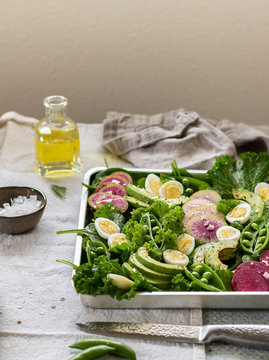 Mustard salad with watermelon radishes, green peas, avocado and quail eggs