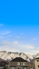 Vertical frame Exterior view of houses with mountain peak covered with snow in the background