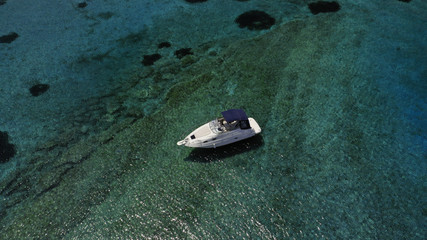 Aerial view of small islet of Ydrousa with turquoise and sapphire clear waters and only one mile distance from coast in Voula, Athens riviera, Attica, Greece