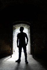 Silhouette of a man in the entrance of a spanish era tunnel in Intramaruos 