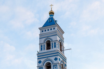 Fototapeta na wymiar The picturesque bell tower of a Christian temple with a golden dome